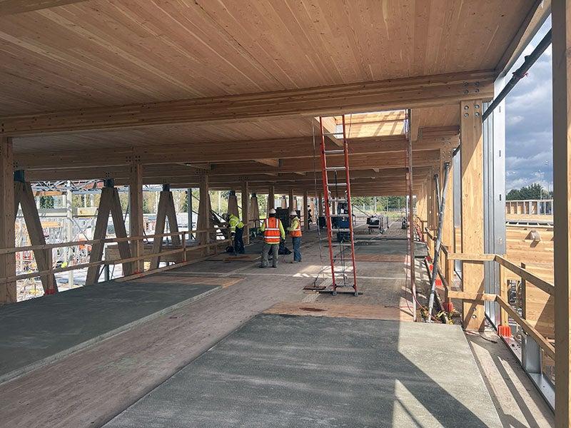 a partially framed building has a wood ceiling resting on wood beams and posts