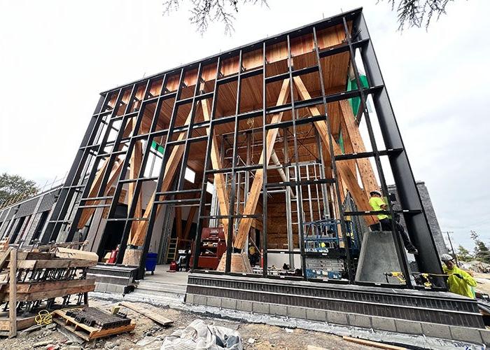 metal framing in front of cross laminated timber bracing and ceiling for a two story building under construction