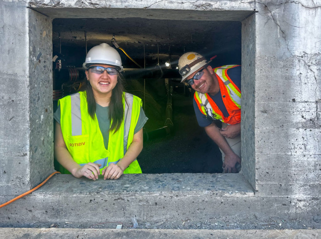 student peering out of concrete pour construction site